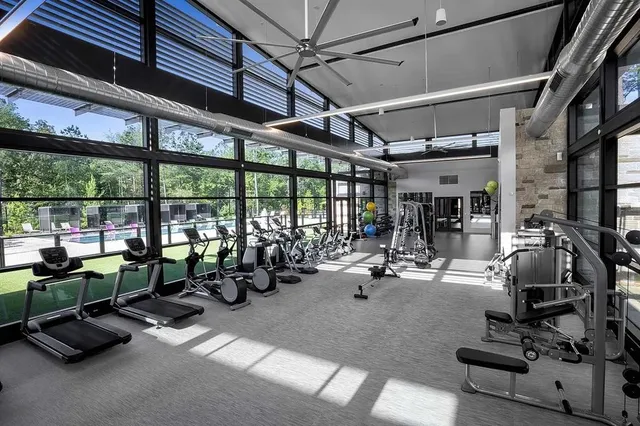 a room with gym equipment and large windows