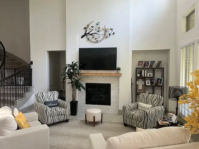a living room with furniture a flat screen tv and a fireplace