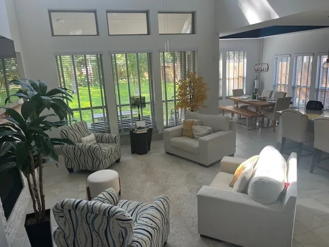 a living room with furniture fireplace and a large window