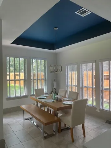a dining room with furniture a chandelier and window