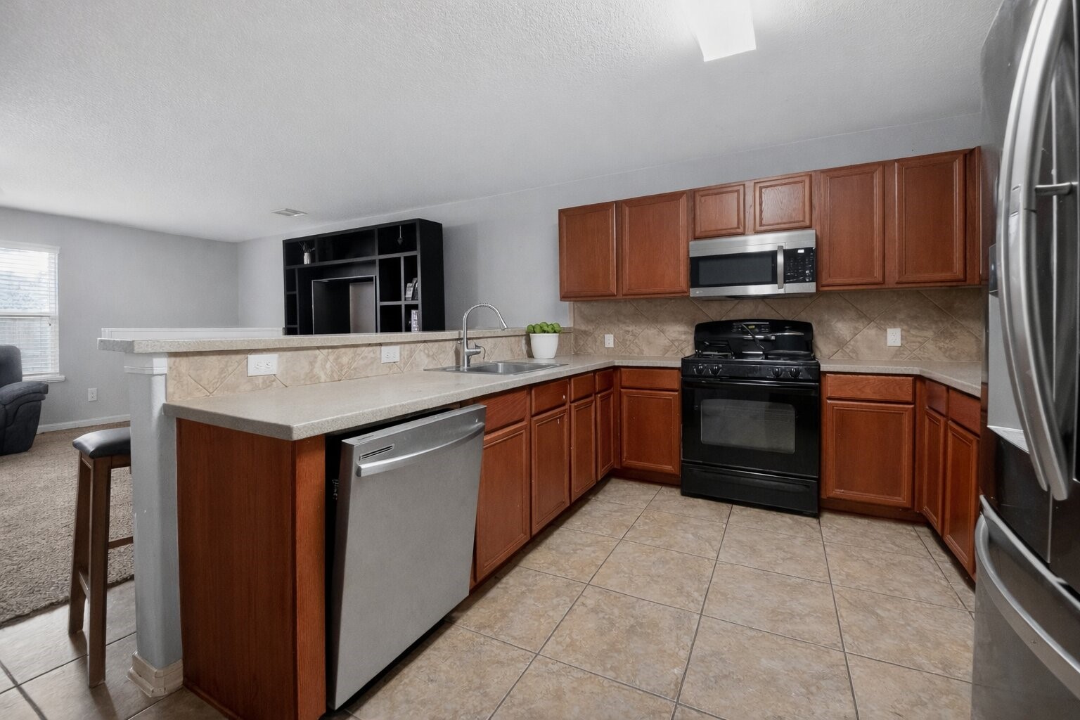 7902 Sesame Street Baytown, TX 77521 - Photo 6 of 24 a kitchen with stainless steel appliances granite countertop a stove microwave and sink