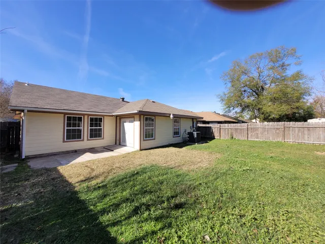 a front view of house with yard and trees in the background