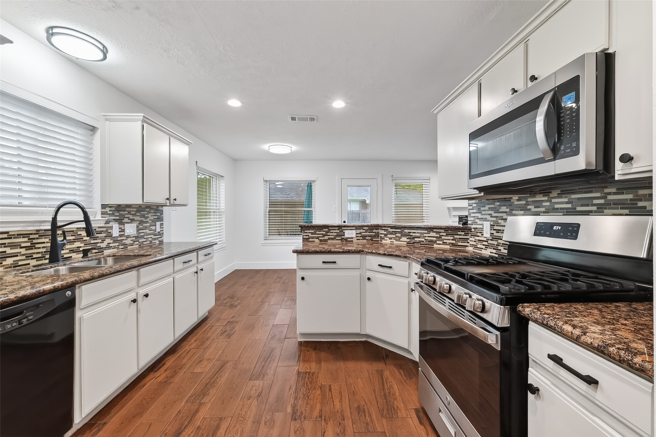 2018 Village Ct Lane Rosenberg, TX 77471 - Photo 11 of 50 a kitchen with stainless steel appliances granite countertop wooden cabinets stove top oven and sink