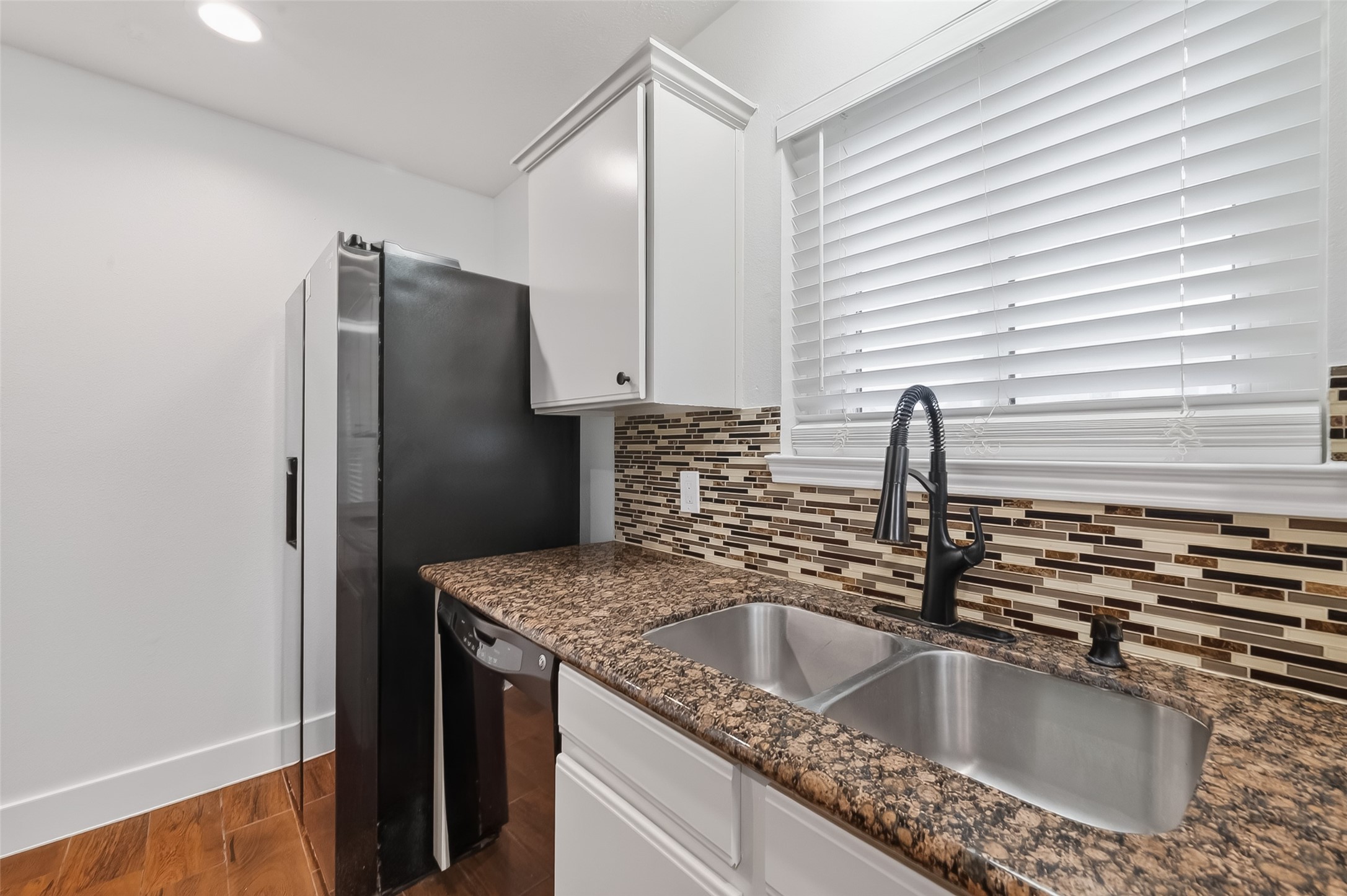 2018 Village Ct Lane Rosenberg, TX 77471 - Photo 15 of 50 a kitchen with granite countertop a sink and a refrigerator