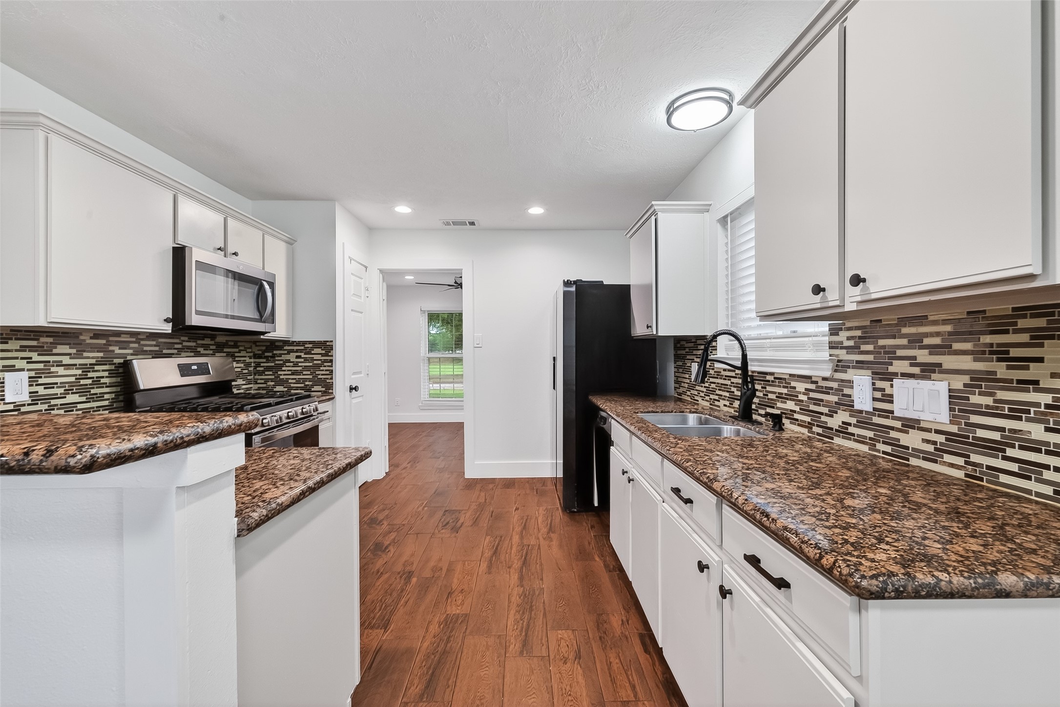 2018 Village Ct Lane Rosenberg, TX 77471 - Photo 17 of 50 a large kitchen with stainless steel appliances granite countertop a stove a sink and a refrigerator