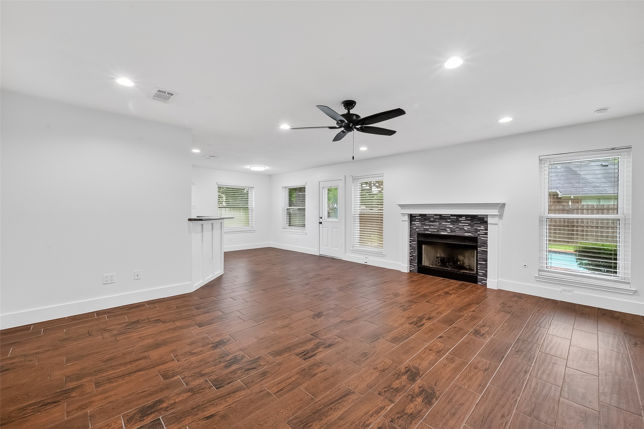 2018 Village Ct Lane Rosenberg, TX 77471 - Photo 24 of 50 an empty room with wooden floor fireplace and windows