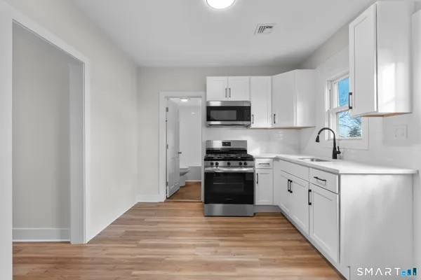 a kitchen with stainless steel appliances a sink stove and cabinets