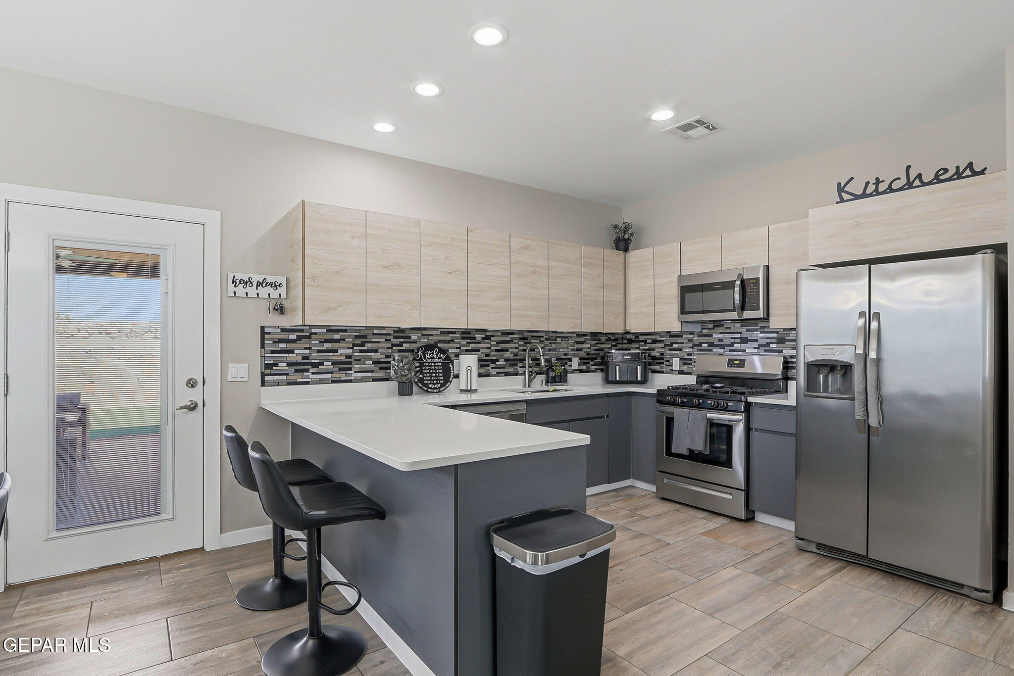 123 Via Rojas Drive Horizon City, TX 79928 - Photo 15 of 47 a kitchen with a refrigerator a sink a stove and chairs