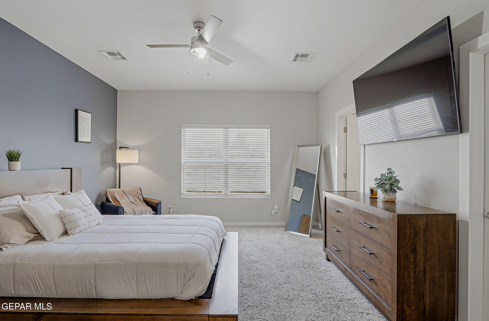 123 Via Rojas Drive Horizon City, TX 79928 - Photo 22 of 47 a bedroom with a large bed and a flat tv screen on dresser