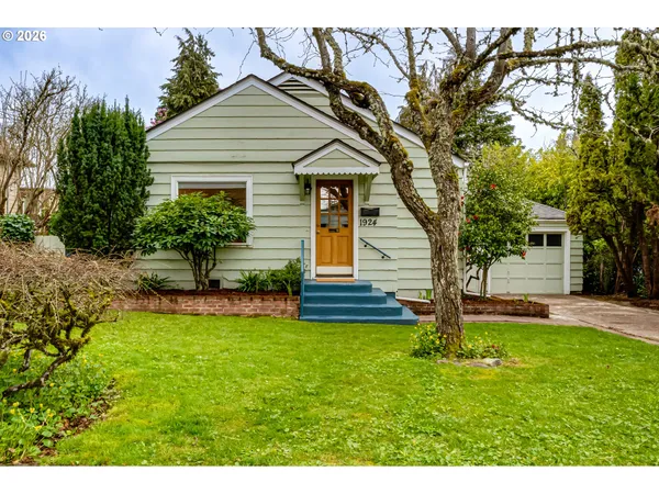 a front view of a house with a yard and trees