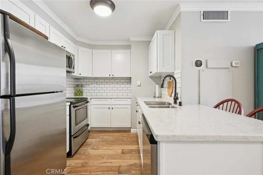 1750 East Ocean Boulevard, Unit 102 Long Beach, CA 90802 - Photo 3 of 22 a kitchen with granite countertop a sink appliances and cabinets