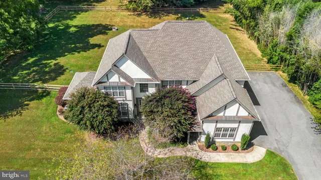 a aerial view of a house with swimming pool next to a yard