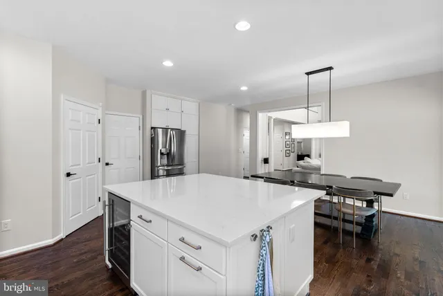 a kitchen with a table chairs refrigerator and microwave