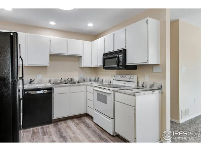 a kitchen with granite countertop white cabinets and white appliances