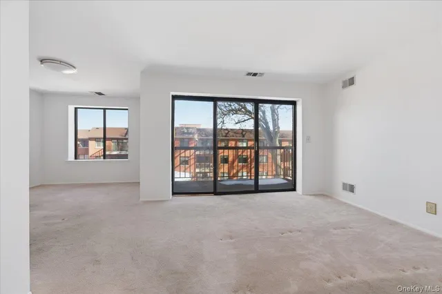 an empty room with windows and view of an empty room