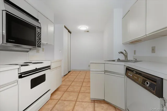 a kitchen with white cabinets stainless steel appliances and sink