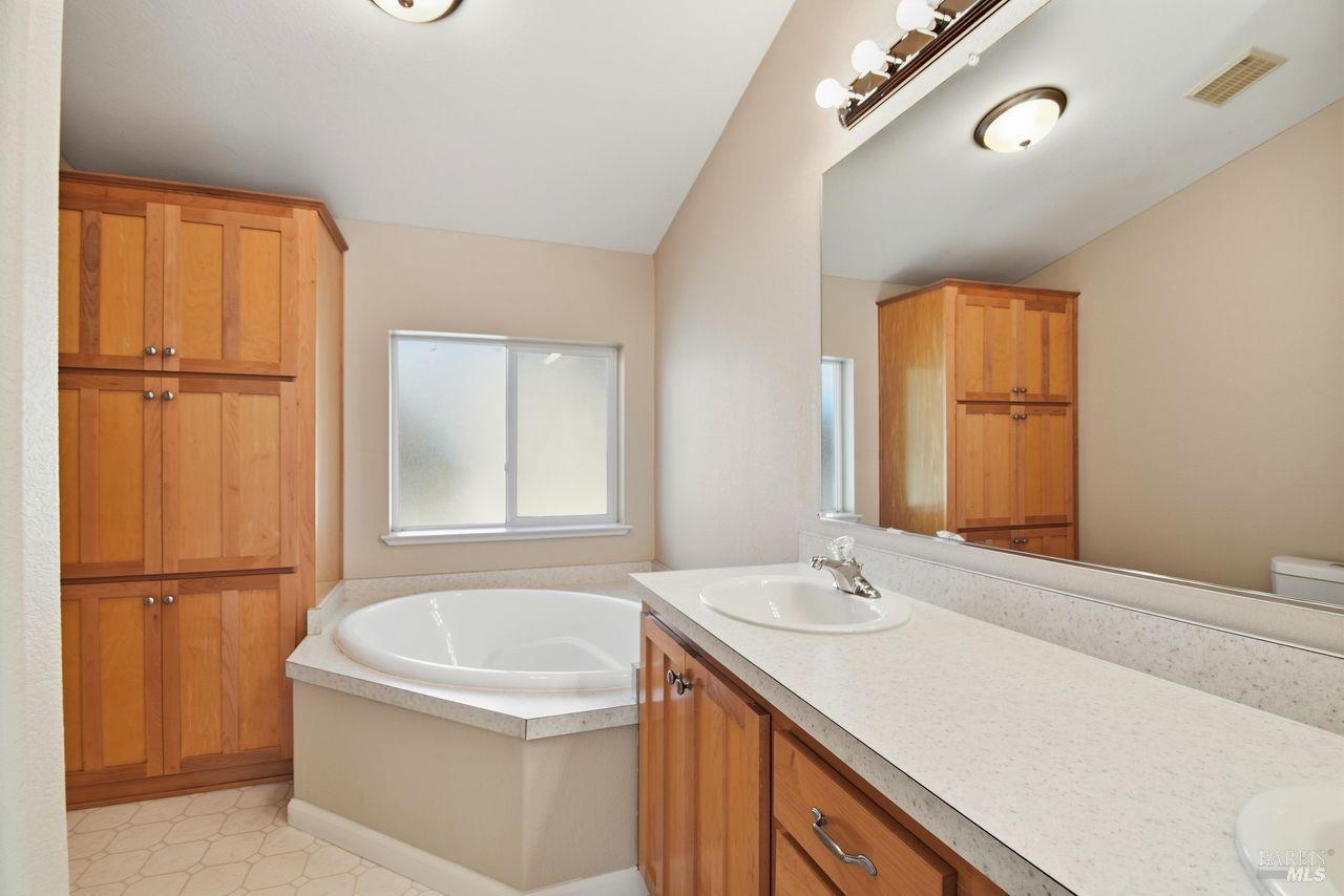 121 Coronado Circle Santa Rosa, CA 95409 - Photo 16 of 32 a bathroom with a granite countertop sink mirror and a bathtub