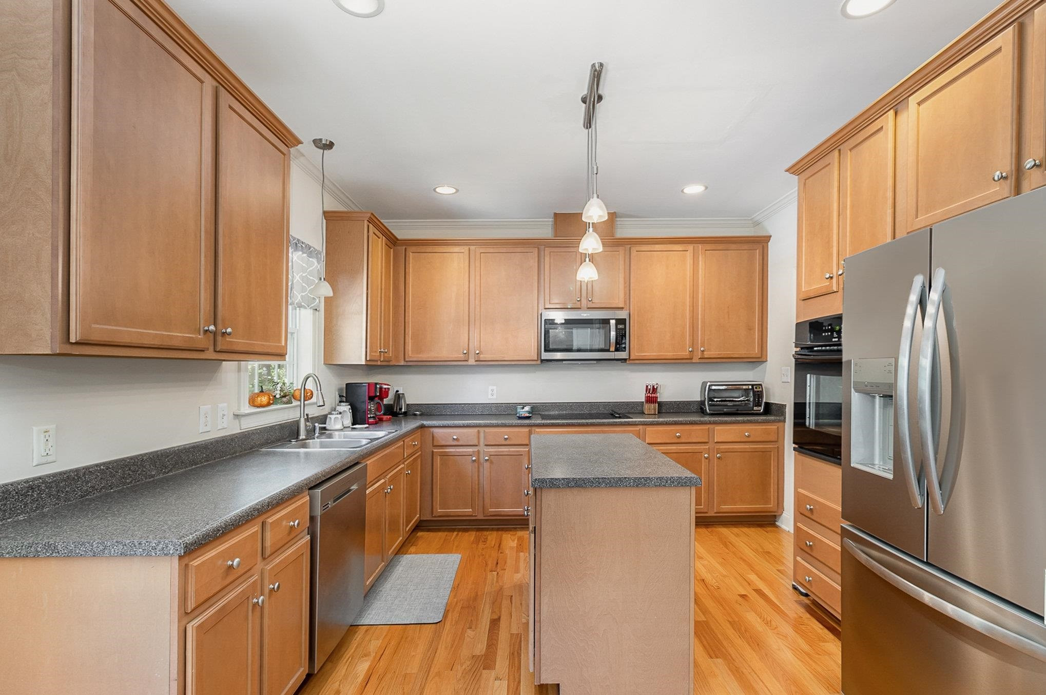 226 Keller Drive Clayton, NC 27520 - Photo 12 of 30 a kitchen with stainless steel appliances a sink a stove a refrigerator cabinets and a counter top space