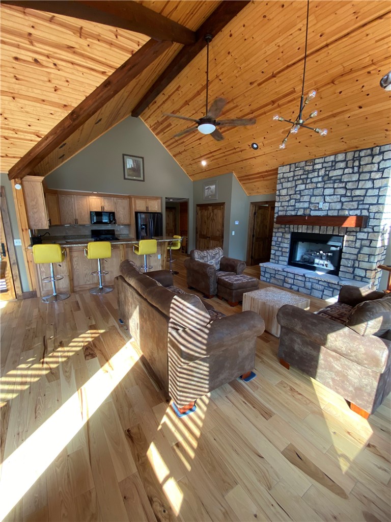 128 McAlister Road West Union, SC 29696 - Photo 23 of 40 Sun-drenched living space featuring a stone fireplace and vaulted wood ceilings.