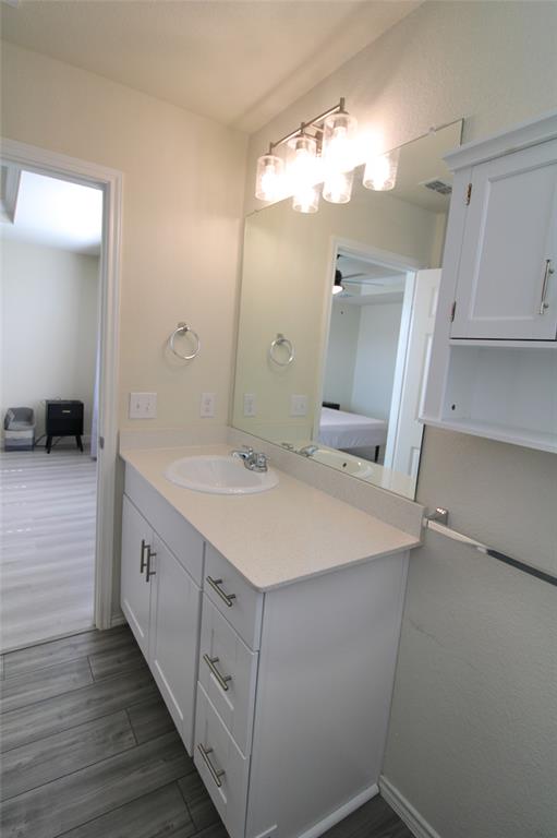 949 Shire Avenue Haslet, TX 76052 - Photo 11 of 22 Bathroom with vanity, dark wood-style floors, a ceiling fan, and ensuite bath