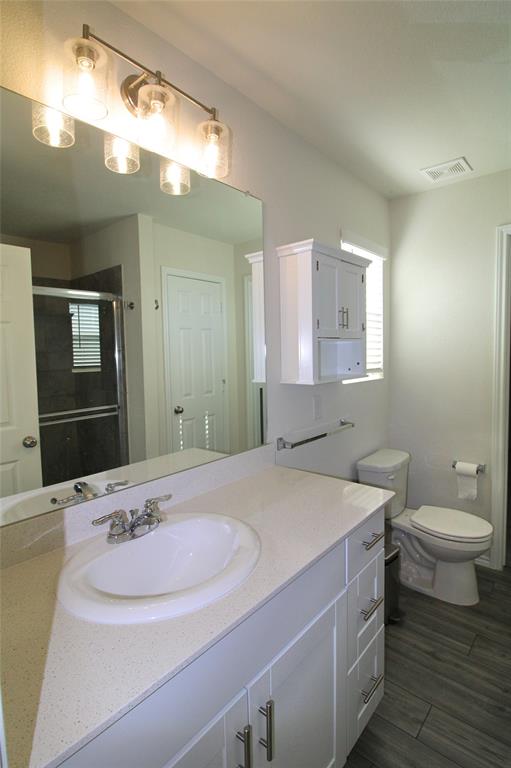 949 Shire Avenue Haslet, TX 76052 - Photo 13 of 22 Full bath featuring vanity, a shower stall, and wood tiled floors