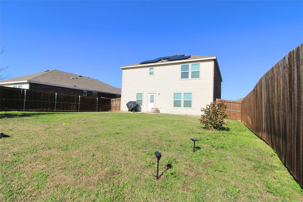 949 Shire Avenue Haslet, TX 76052 - Photo 15 of 22 Rear view of house featuring a fenced backyard and roof mounted solar panels