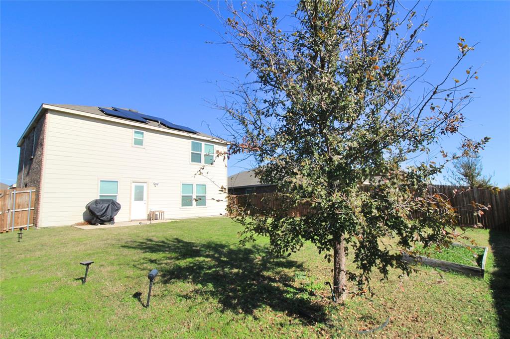 949 Shire Avenue Haslet, TX 76052 - Photo 17 of 22 Back of property featuring a fenced backyard and solar panels