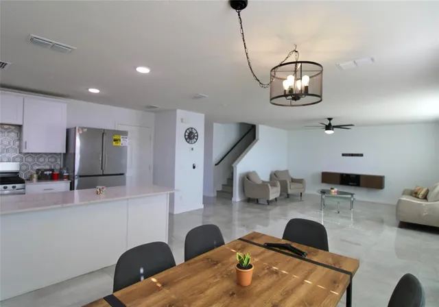 a kitchen with stainless steel appliances kitchen island granite countertop a stove and white cabinets