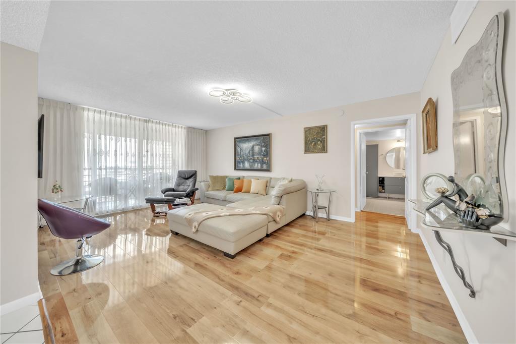 a spacious bedroom with a bed a couch and large windows