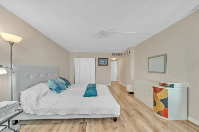 a bed sitting in a bedroom next to a bathroom sink and a mirror