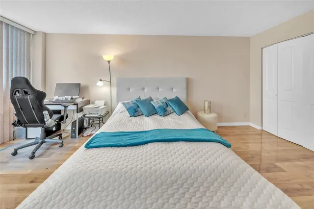 a bedroom with a bed gym equipment and view of living room