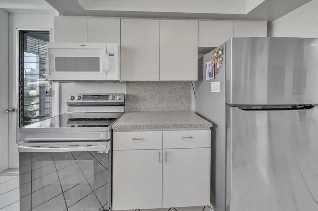 a kitchen with stainless steel appliances white cabinets and a refrigerator
