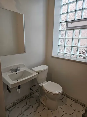 a white toilet sitting next to a bathroom sink