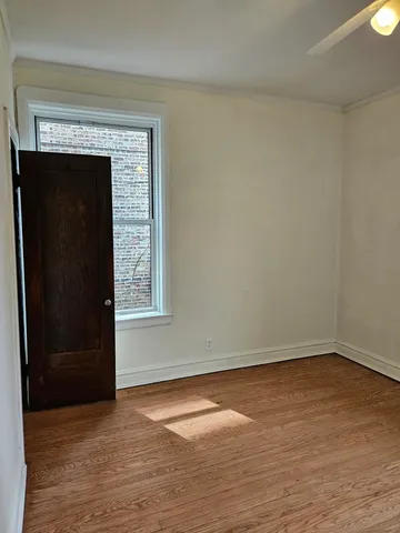 an empty room with wooden floor and fireplace