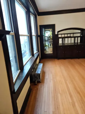 a view of an empty room with wooden floor and windows