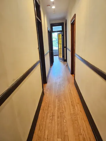 a view of hallway with wooden floor and stairs