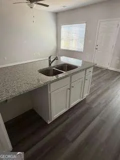 a kitchen with stainless steel appliances granite countertop a sink dishwasher a stove a refrigerator and white cabinets