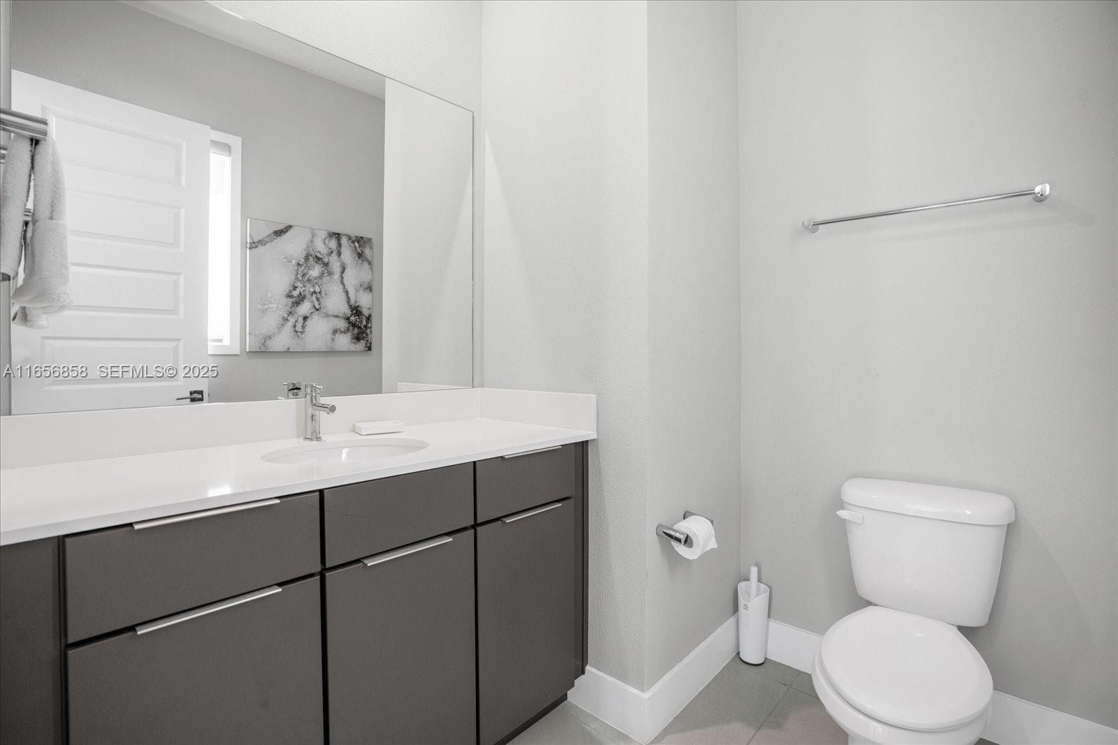 7740 Sandy Ridge Drive, Unit 112 Kissimmee, FL 34747 - Photo 20 of 38 a bathroom with a toilet sink and mirror