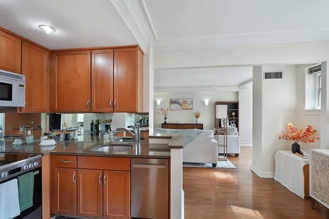 a kitchen with granite countertop a sink dishwasher stove and cabinets