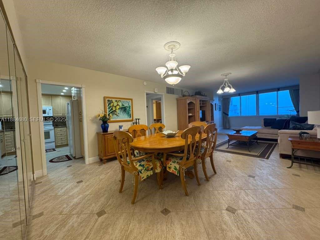 5005 Collins Avenue, Unit 714 Miami Beach, FL 33140 - Photo 11 of 36 a view of a dining room with furniture and wooden floor