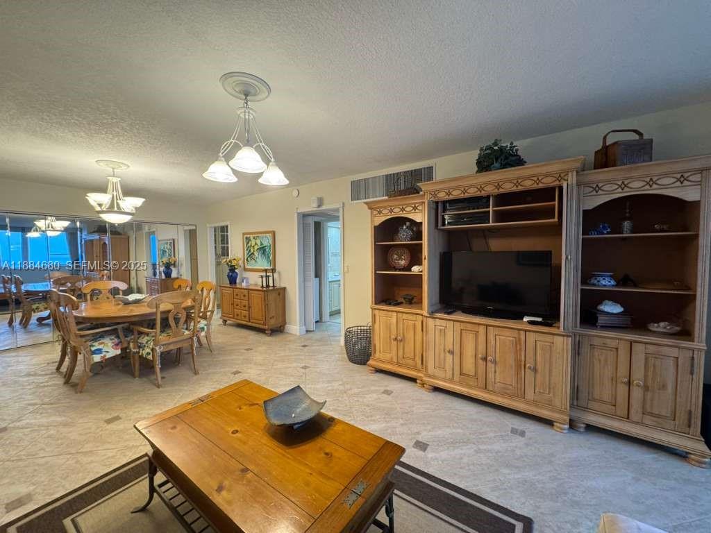 5005 Collins Avenue, Unit 714 Miami Beach, FL 33140 - Photo 13 of 36 a living room with furniture and a flat screen tv
