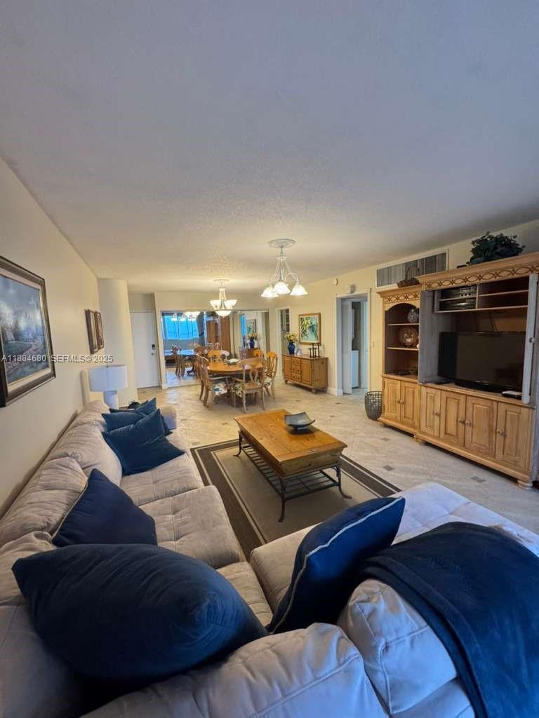 5005 Collins Avenue, Unit 714 Miami Beach, FL 33140 - Photo 14 of 36 a living room with furniture and a flat screen tv