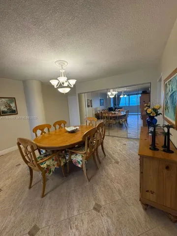 a living room with dining table and a chandelier