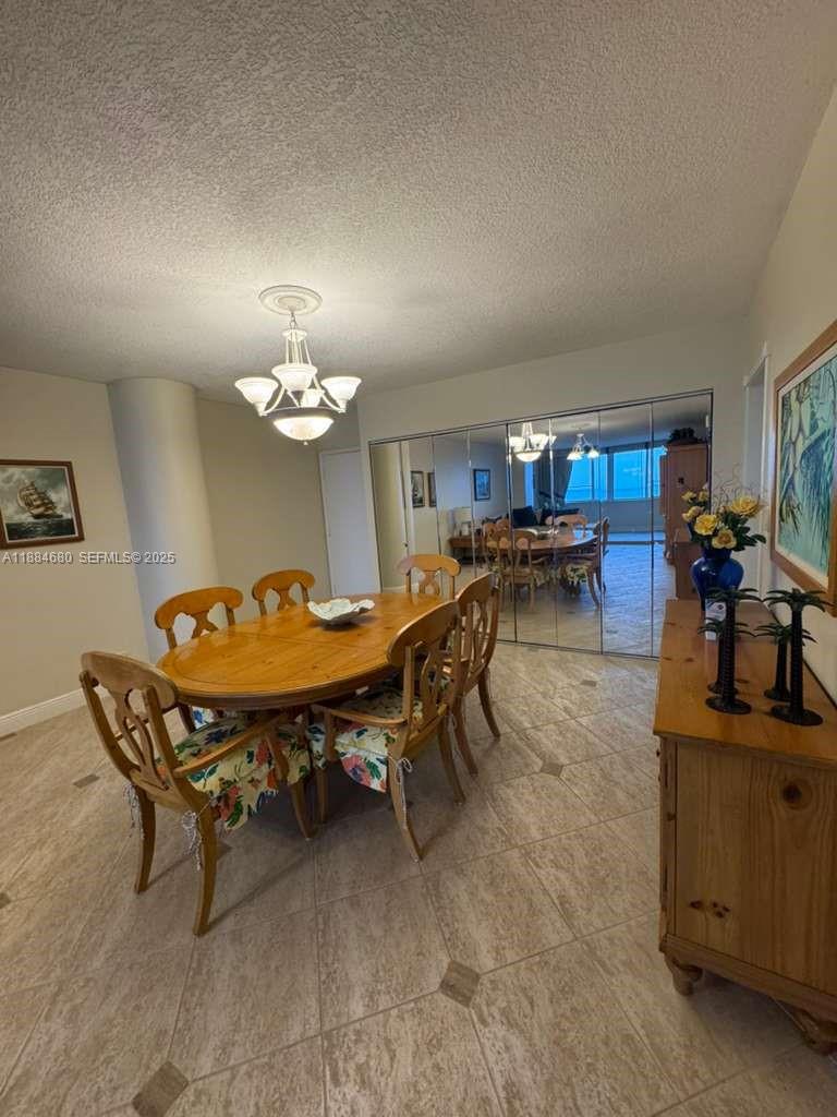 5005 Collins Avenue, Unit 714 Miami Beach, FL 33140 - Photo 18 of 36 a living room with dining table and a chandelier