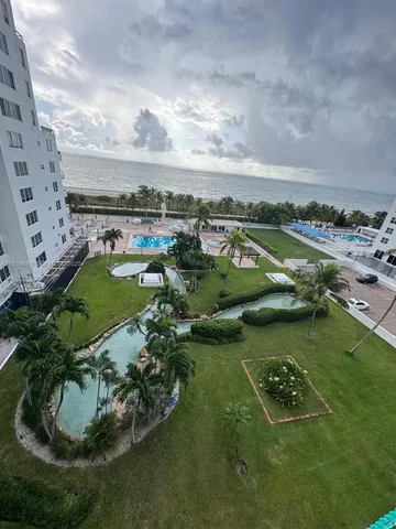 an aerial view of a residential houses with outdoor space and lake view
