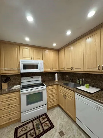 a kitchen with a sink stove and microwave