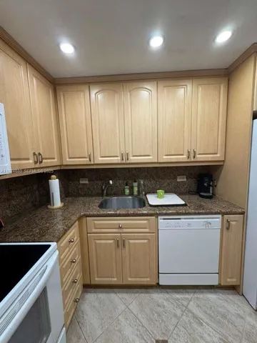 a kitchen with stainless steel appliances granite countertop a stove a sink and white cabinets