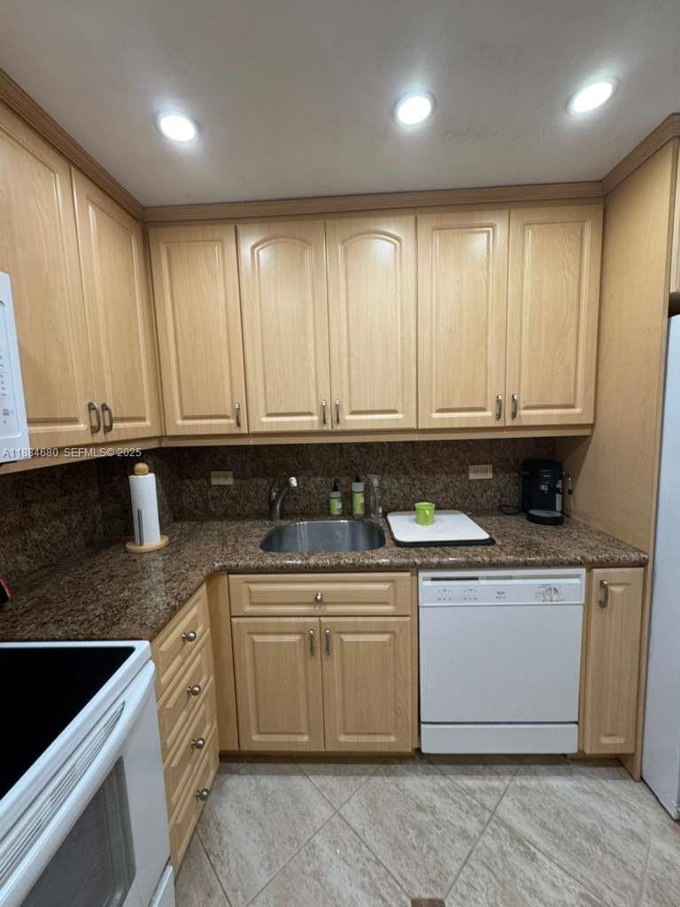5005 Collins Avenue, Unit 714 Miami Beach, FL 33140 - Photo 5 of 36 a kitchen with stainless steel appliances granite countertop a stove a sink and white cabinets