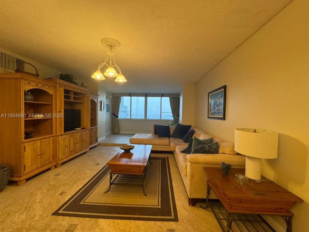 5005 Collins Avenue, Unit 714 Miami Beach, FL 33140 - Photo 7 of 36 a living room with couches and kitchen view with wooden floor