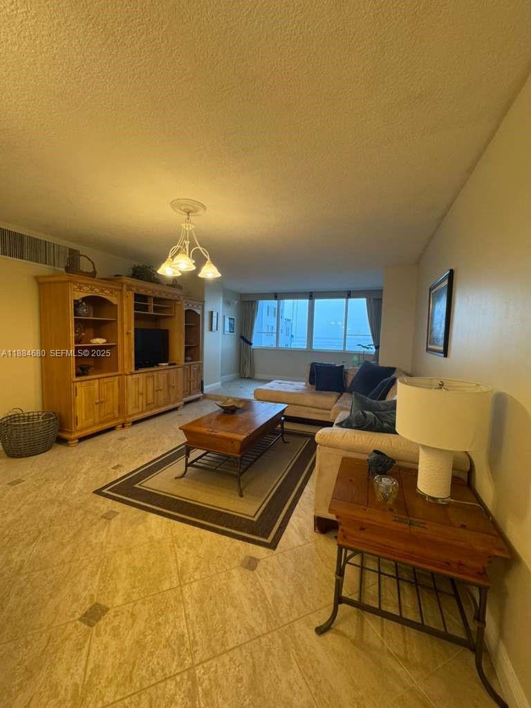 5005 Collins Avenue, Unit 714 Miami Beach, FL 33140 - Photo 10 of 36 a living room with furniture a flat screen tv and kitchen view